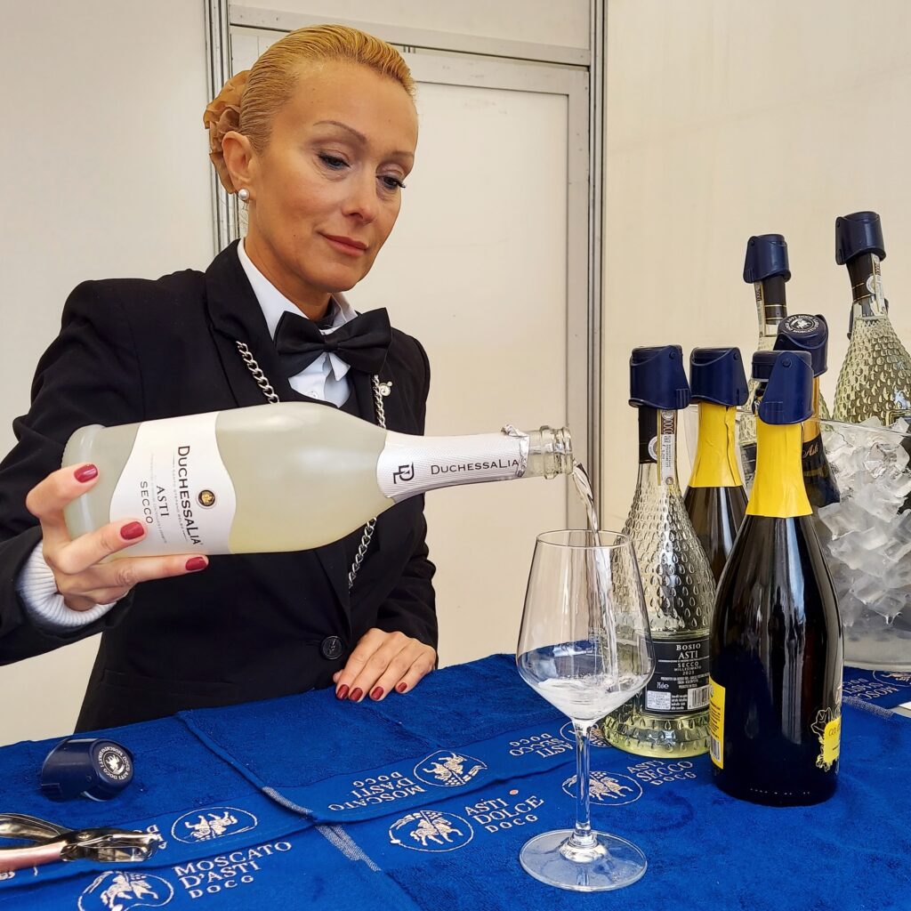 Sommelier pouring a sample of Asti secco at Vinum Alba Italy Piazza Rossetti